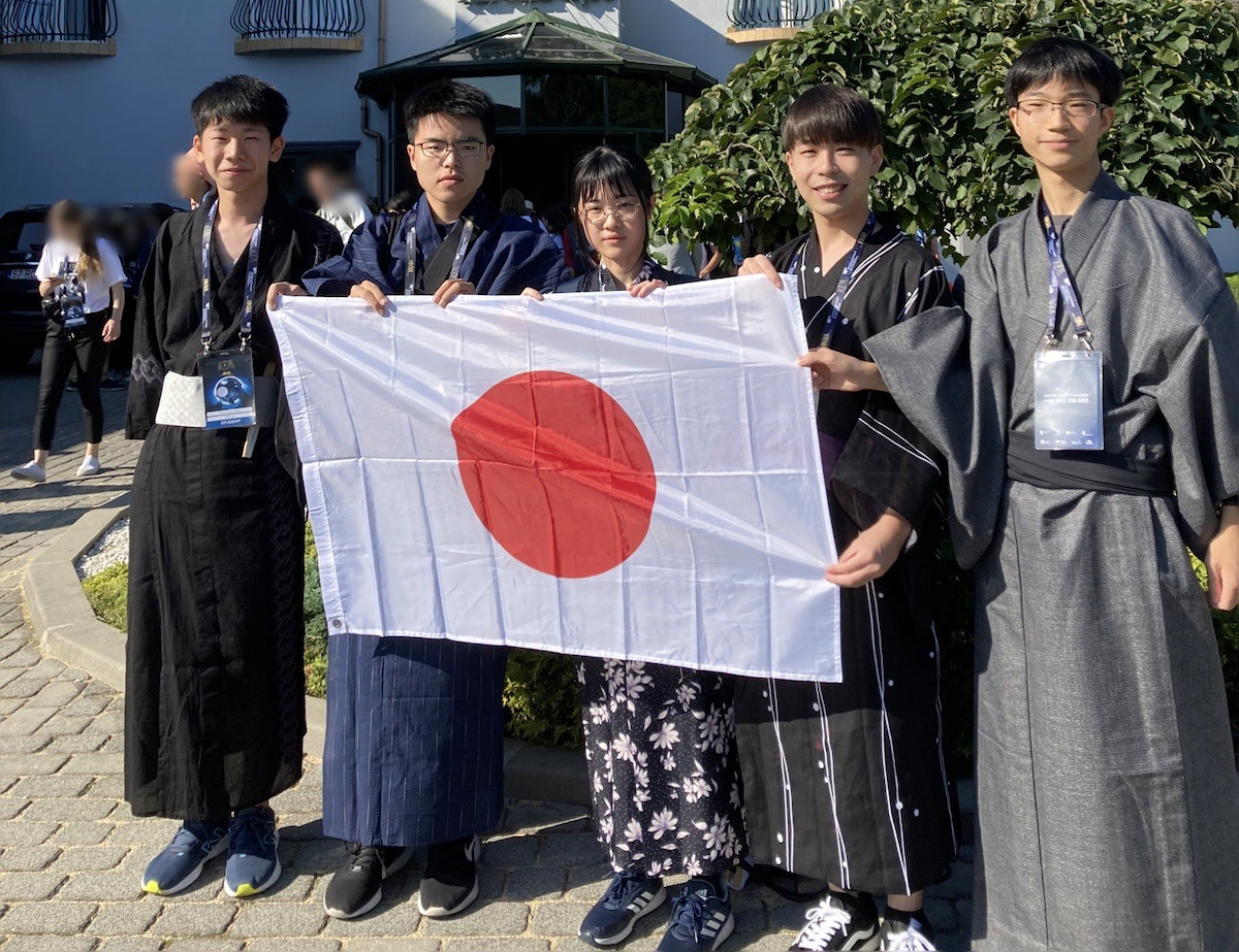 IOAA2023日本代表団の集合写真。浴衣を着た生徒5人が並んで、日本国旗を持っている。